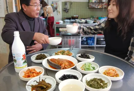 韓国の家庭的な食卓でマッコリを囲む様子